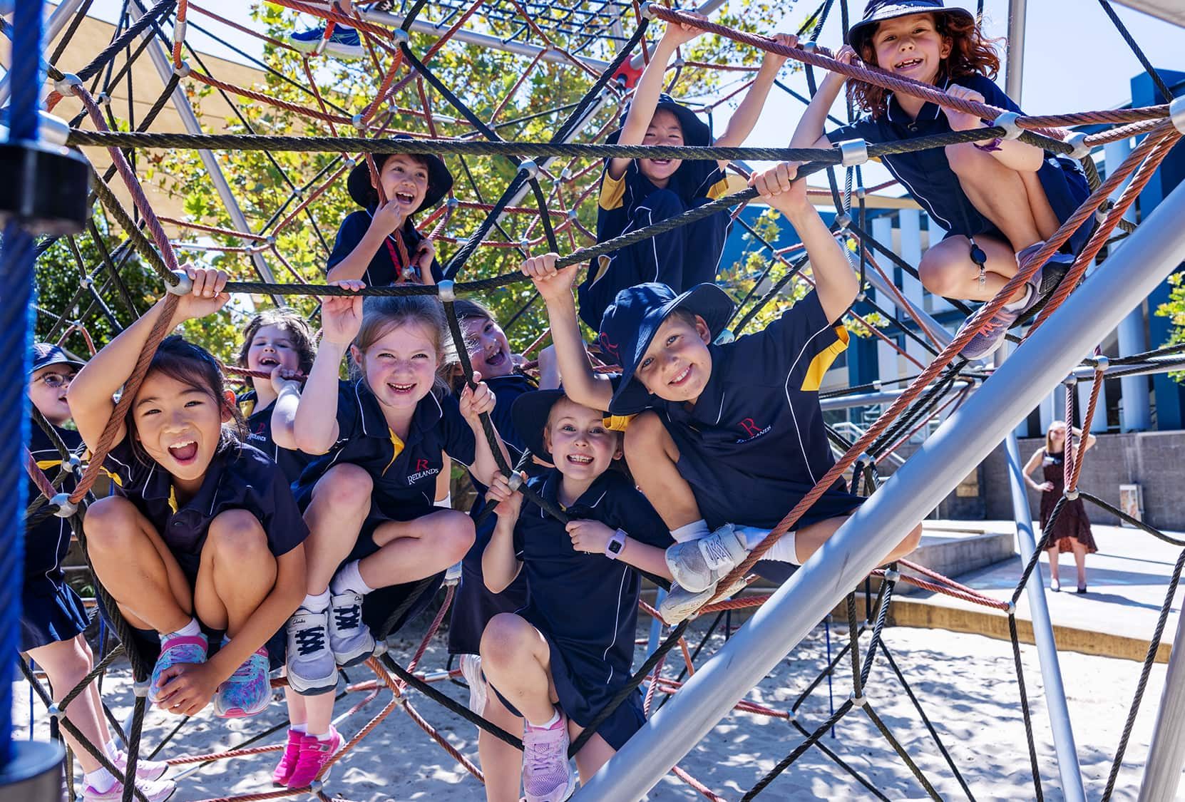 A group of Redlands Preparatory School students playing outside on play equipment